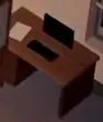 Wooden desk with a monitor and keyboard.
